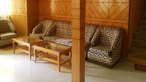 Una habitación con un sofá estampado, una mesa de centro de madera y una pared decorada con un diseño.