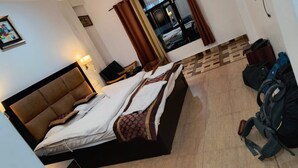 Una habitación de hotel con una cama, un escritorio y una maleta.