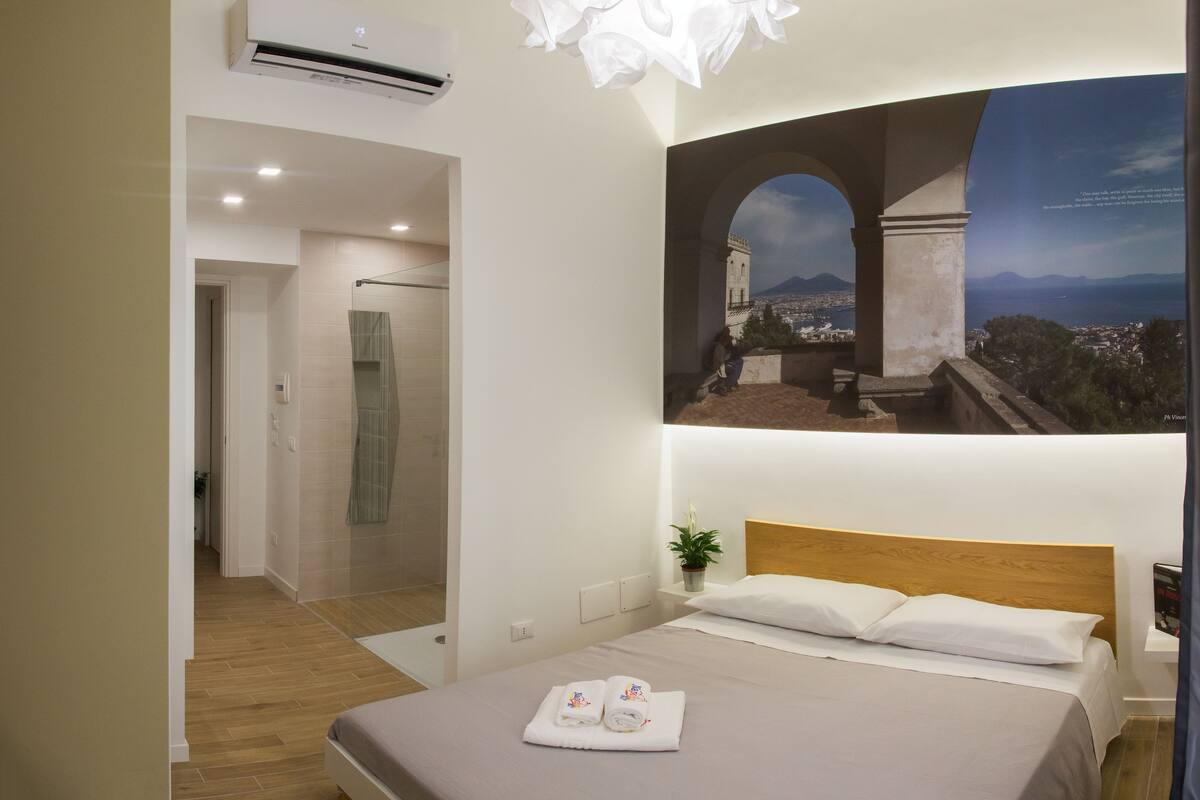 Une chambre d’hôtel équipée d’un lit, d’une douche, offrant une vue sur le paysage urbain et disposant de la climatisation.