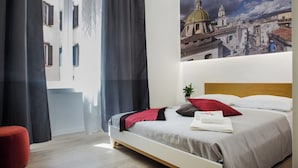 A hotel room with a bed, a red chair, a painting of a cityscape, and a window with curtains. - Napolinn B&B (Naples)