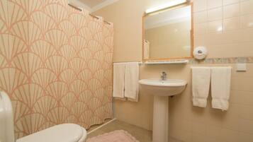 Ein Badezimmer mit Toilette, Waschbecken und Duschvorhang.