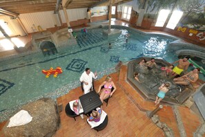 An indoor swimming pool with a hot tub, tiled flooring, and a mural on the wall. - Hassela Ski Resort Cabins (Hassela)