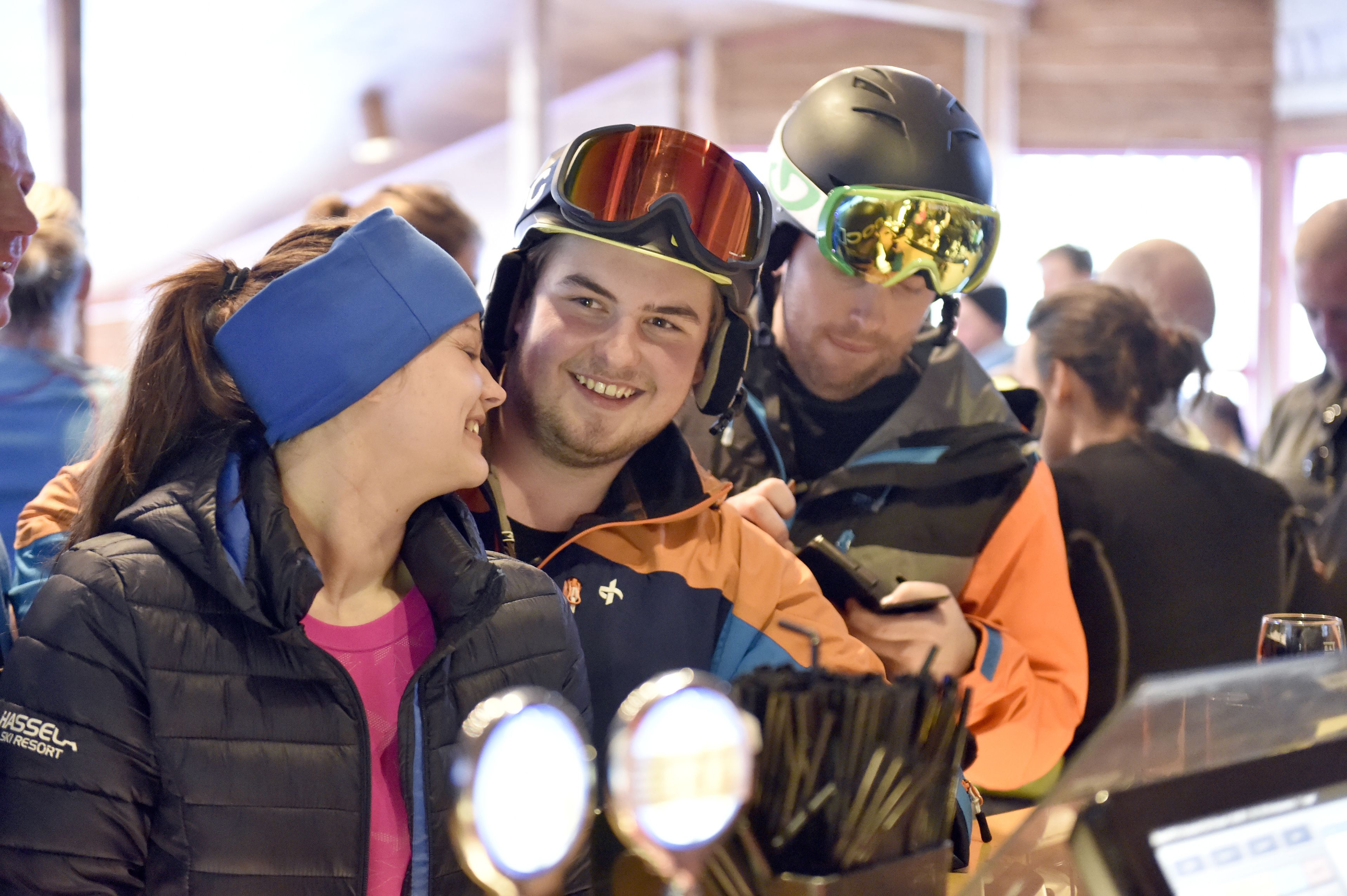 A group of people at an indoor event, some wearing helmets and jackets.