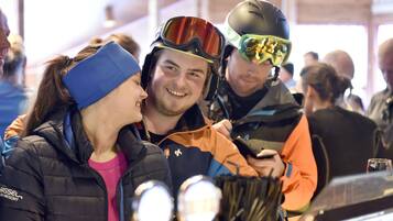 A group of people at an indoor event, some wearing helmets and jackets.