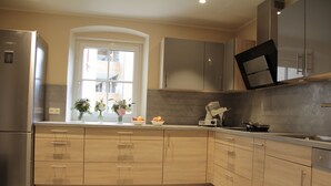 Una cocina moderna con armarios de madera, horno empotrado y ventana con vistas al exterior.