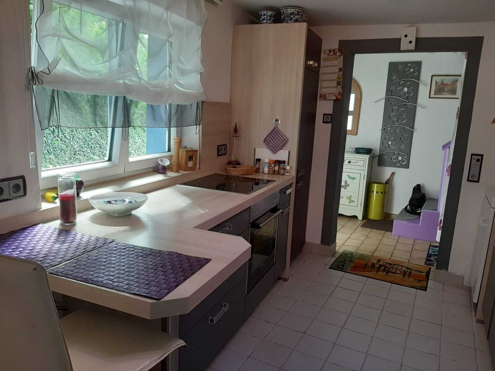 Una cocina con ventana, lavamanos, armarios y estufa.