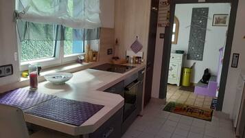 Una cocina con ventana, lavamanos, armarios y estufa.