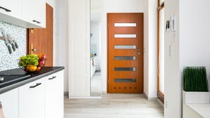 A modern kitchen with white cabinets, a black countertop, and a fruit bowl. - Green Garden Residence (Kraków)