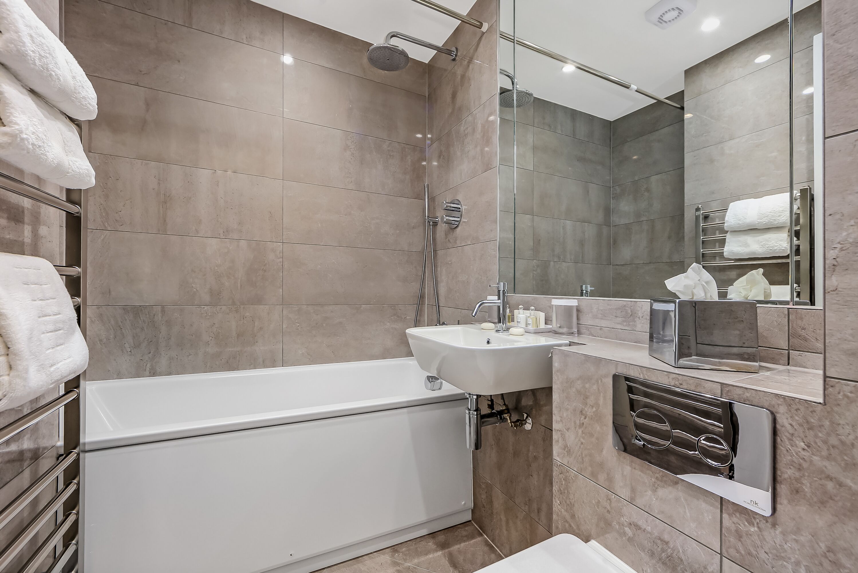 A modern bathroom with a bathtub, a sink, and a glass shower enclosure.