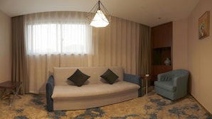 A living room with a sofa, a chair, a small table, and a decorative light fixture. - Metropolo Nanjiang Baijia Lake (Nanjing)