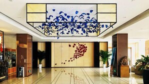 A spacious lobby with a polished floor, a large decorative ceiling, and a reception desk with a modern design. - Metropolo Nanjiang Baijia Lake (Nanjing)
