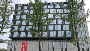 A modern building with a glass facade and multiple floors. - Yilong Hotel (Nanjing Southeast University Branch) (Nanjing)