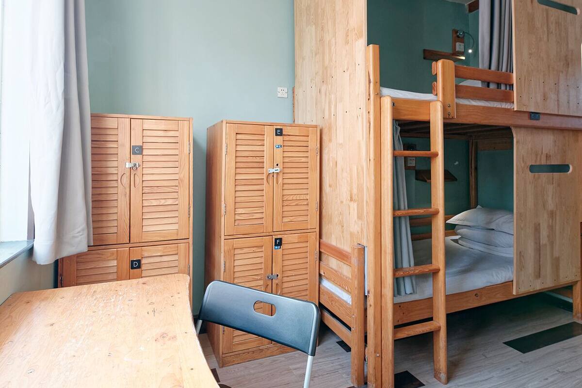 A room with bunk beds, a desk, and a chair.