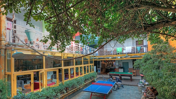 Espacio al aire libre con mesa de ping pong, asientos y mesa de billar.