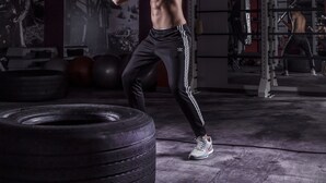 A gym with exercise equipment, including a tire, a barbell, and a weight bench. - Grape Town Hotel (Zielona Gora)