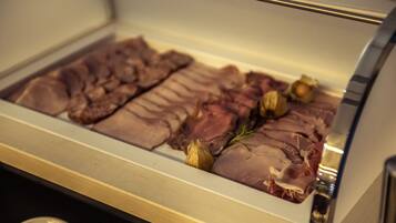 A display case with various cuts of meat and herbs.