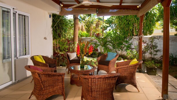 Un patio cubierto con muebles de mimbre y plantas en macetas.