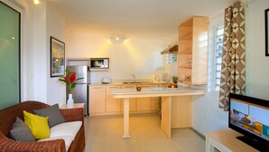 Una cocina moderna con comedor, sofá y televisor.
