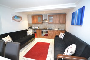 Apartamento, 2 quartos | Área de estar | TV de tela plana