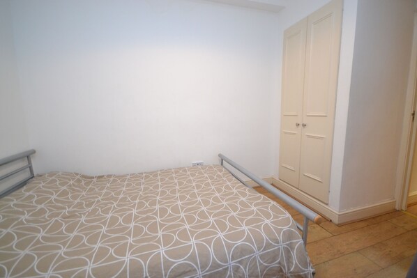 Un dormitorio con cama, armario y radiador.