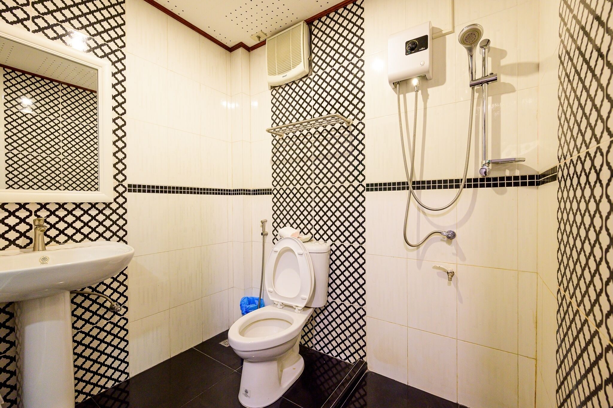 A bathroom with a toilet, sink, and shower.