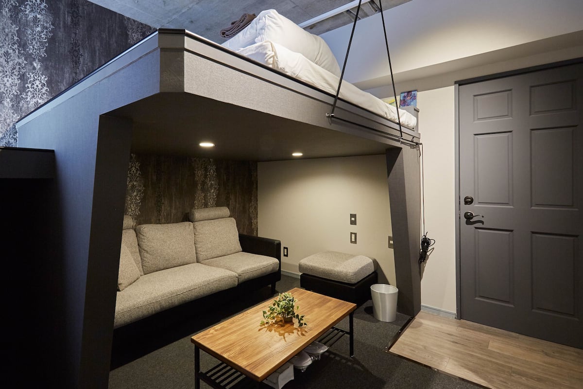 A compact living space with a sofa, a small table, and a bench.