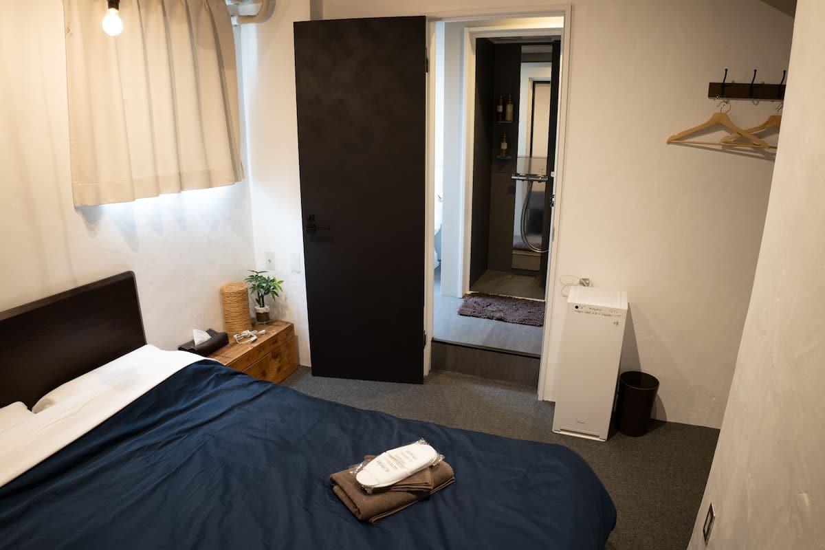 A bedroom with a bed, bedside table, and a wardrobe.