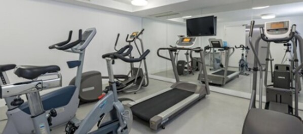 A gym with various exercise equipment including treadmills, stationary bikes, and elliptical machines. - Hotel Eurostars Central (Madrid)