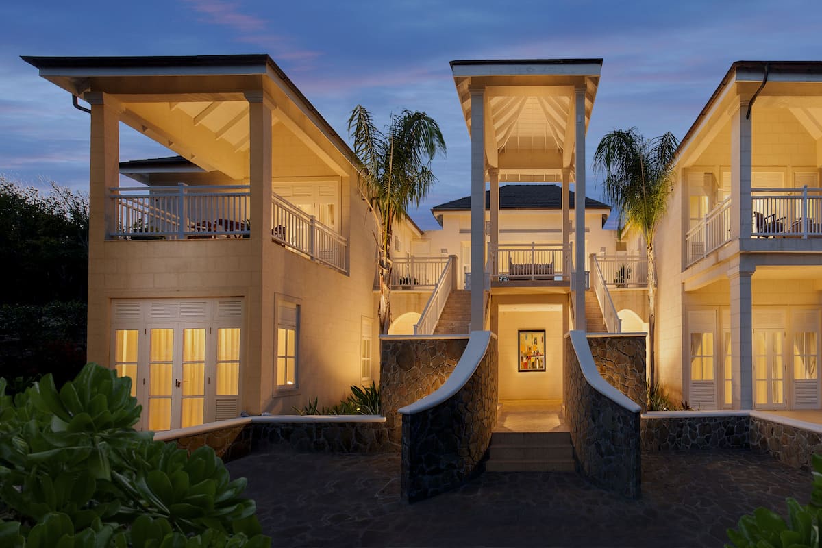 A multi-story house with a central staircase, balconies, and a stone facade.