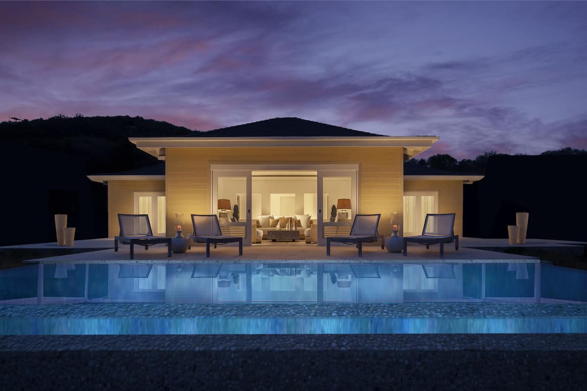 A modern house with a swimming pool, a patio with chairs, and a view of the interior.