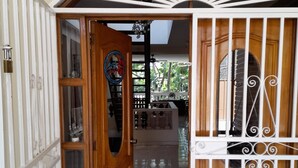 A wooden door with a glass panel and a metal gate. - Star House (Port-au-Prince)