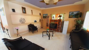 A living room with a sofa, a TV, and a cabinet. - Star House (Port-au-Prince)
