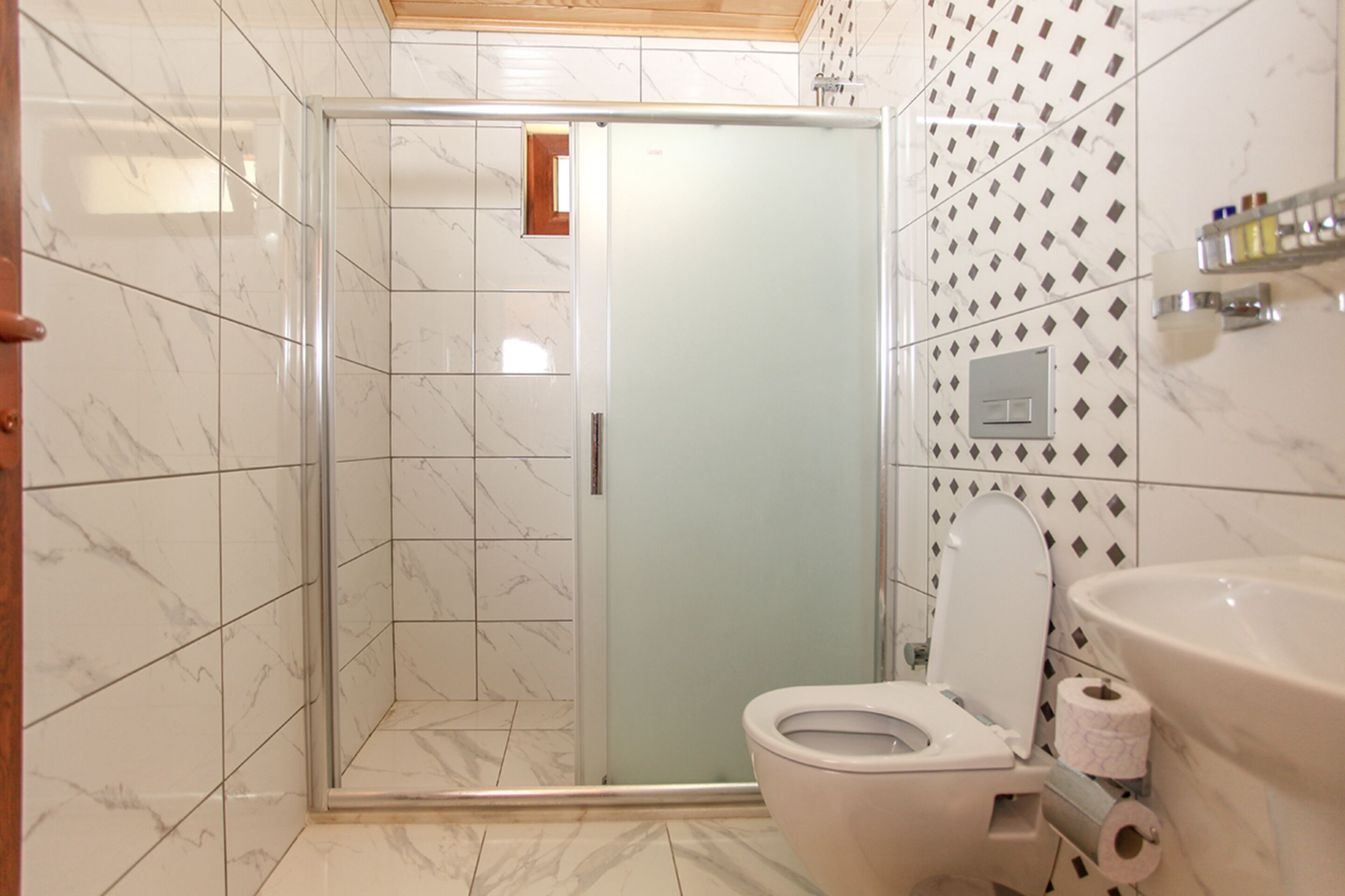 A bathroom with a shower, toilet, and sink.