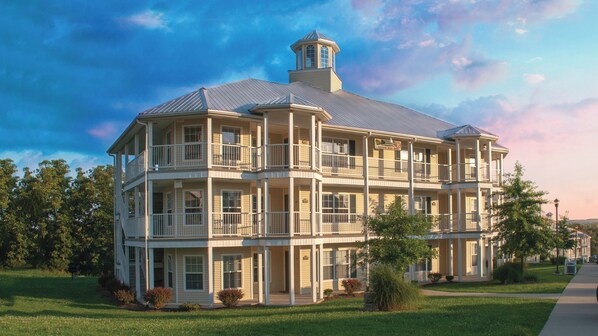 A multi-story building with a prominent tower, balconies, and a covered front porch. - Holiday Inn Club Vacations Holiday Hills Resort Branson by IHG (Branson)