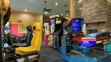 A room with arcade games, a craft room, and a ceiling fan.