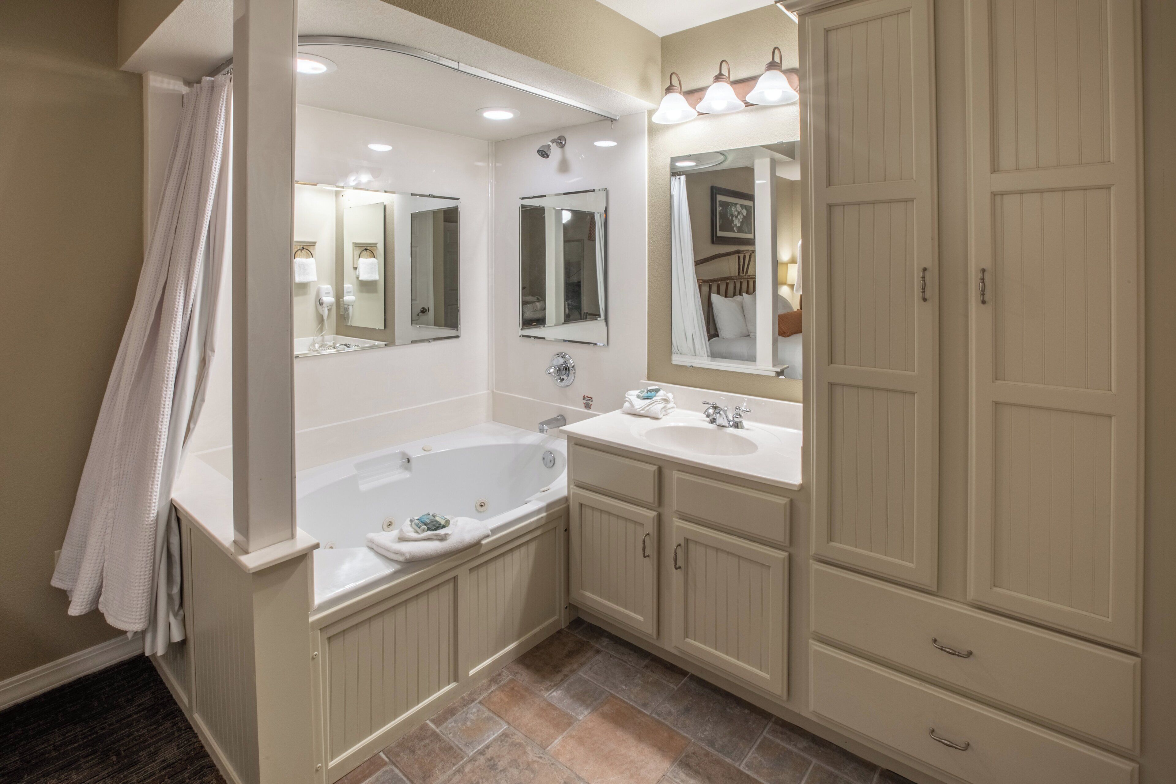 Une salle de bain avec une baignoire, deux lavabos et un grand miroir.