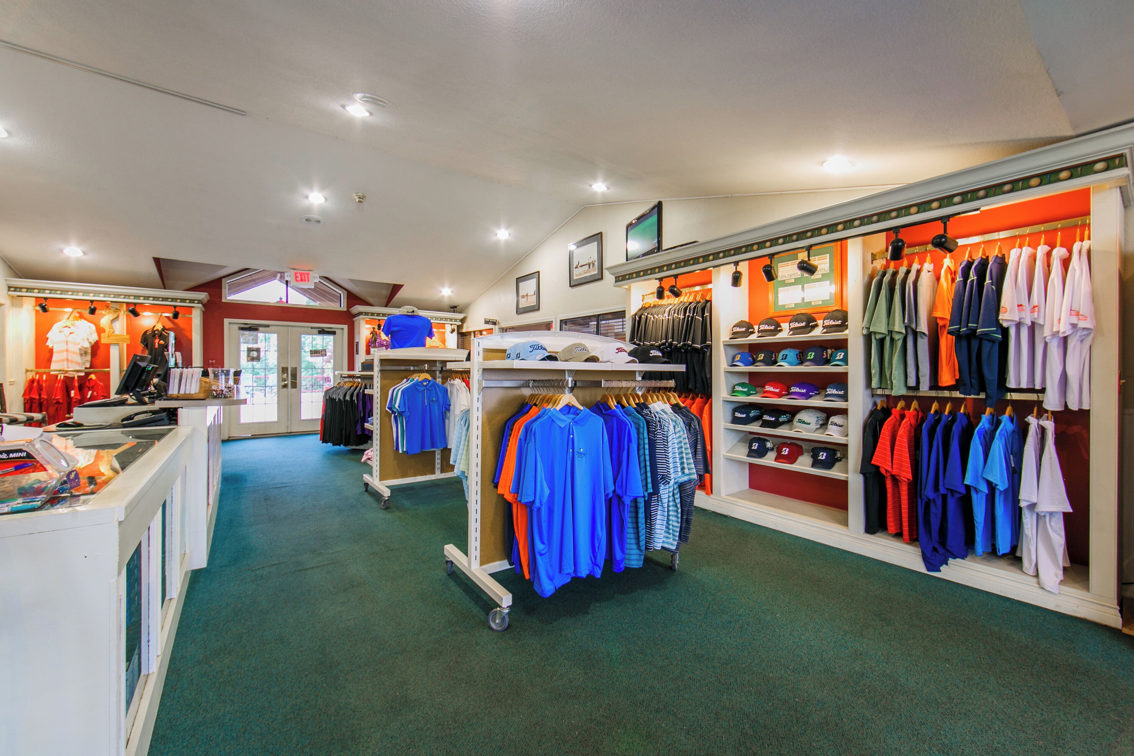 A clothing store with various apparel on racks and shelves.