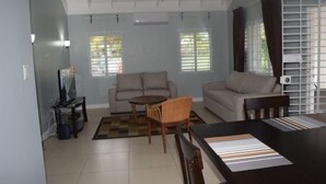 A living room with a sofa, a coffee table, and a TV stand. - Richmond Estate (St. Ann's Bay)