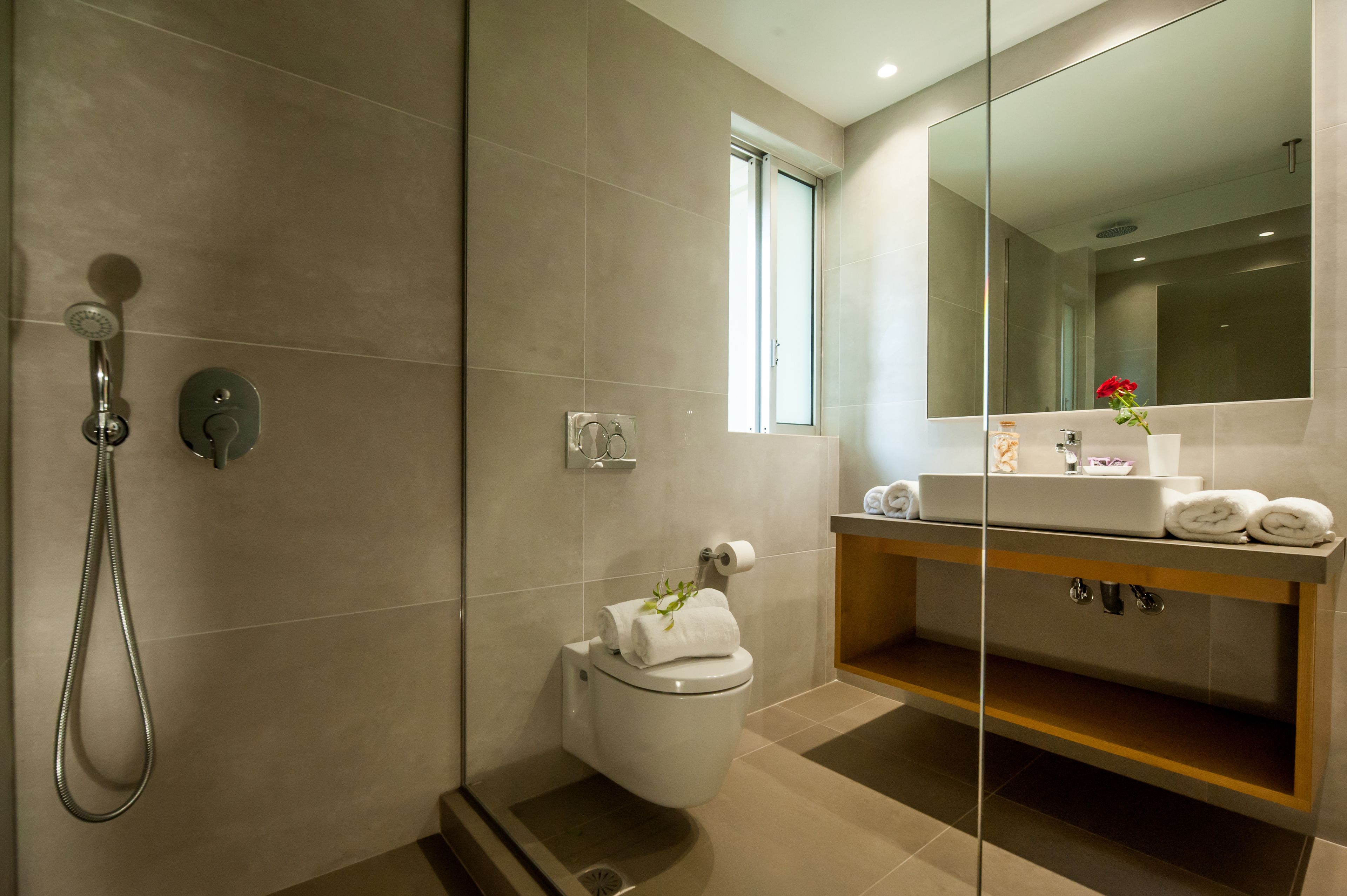A modern bathroom with a shower, toilet, and vanity.