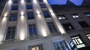A multi-story building with illuminated windows and balconies, featuring a prominent 'DRESS CODE' sign. - Hôtel Dress Code (Paris)