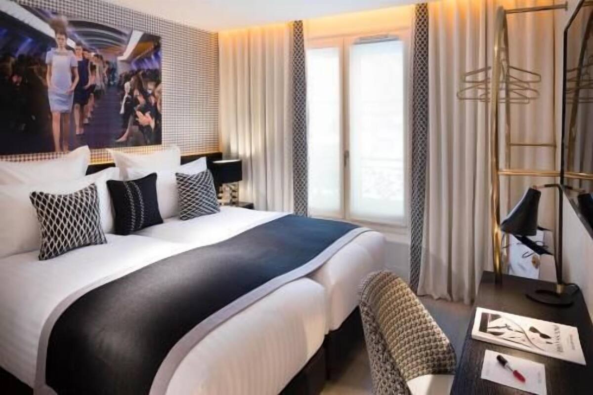 Habitació d'hotel moderna amb un llit gran, un escriptori i vistes a la ciutat.