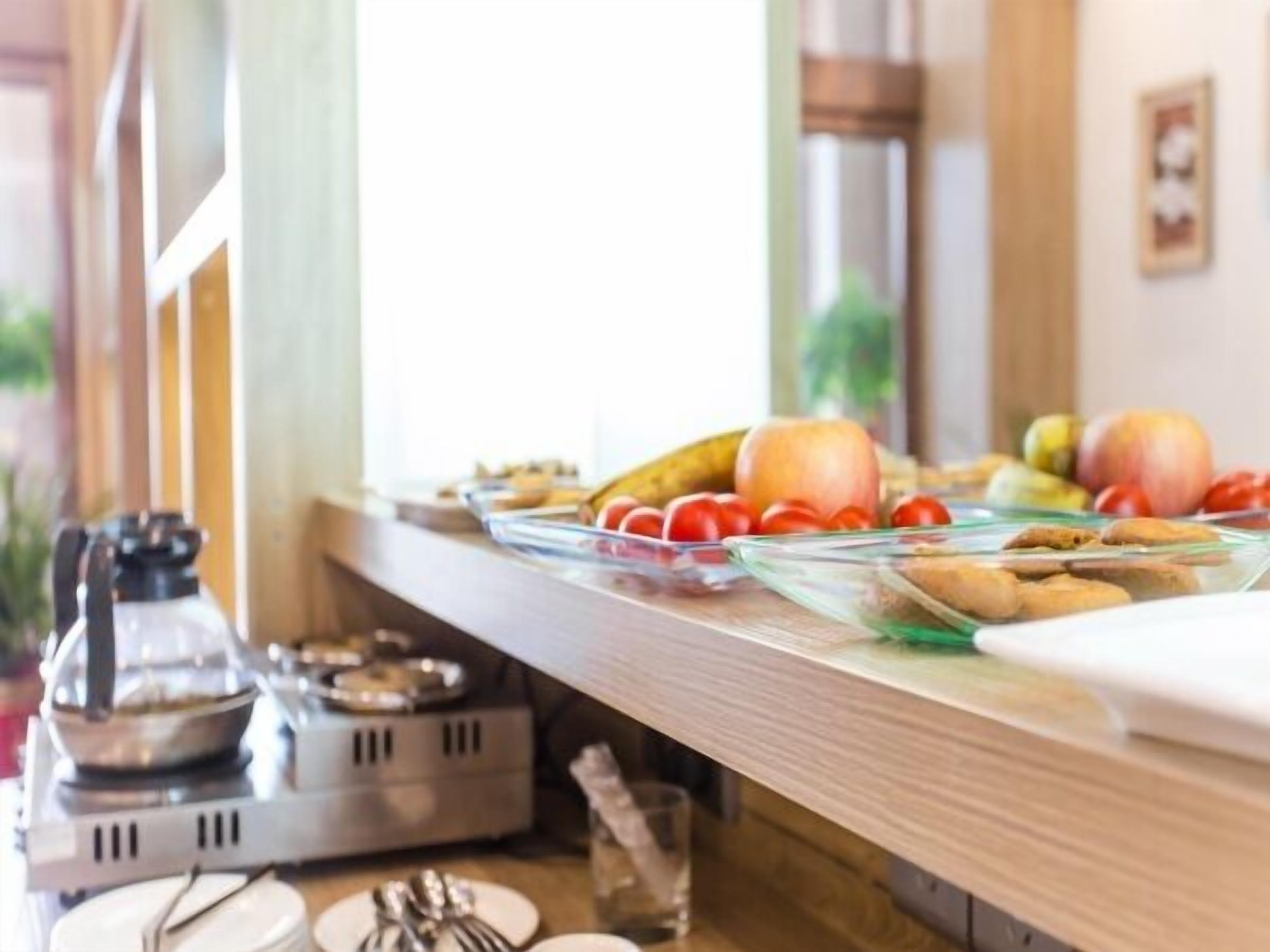 A breakfast buffet with various fruits and pastries.