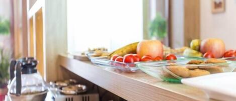 Un bufé de desayuno con diversas frutas y pasteles.