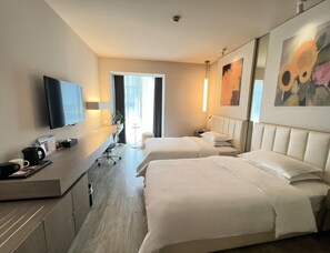 A hotel room with two beds, a desk with a flat-screen TV, a coffee maker, and a plant. - Metropolo Hangzhou Railway Station East (Hangzhou)