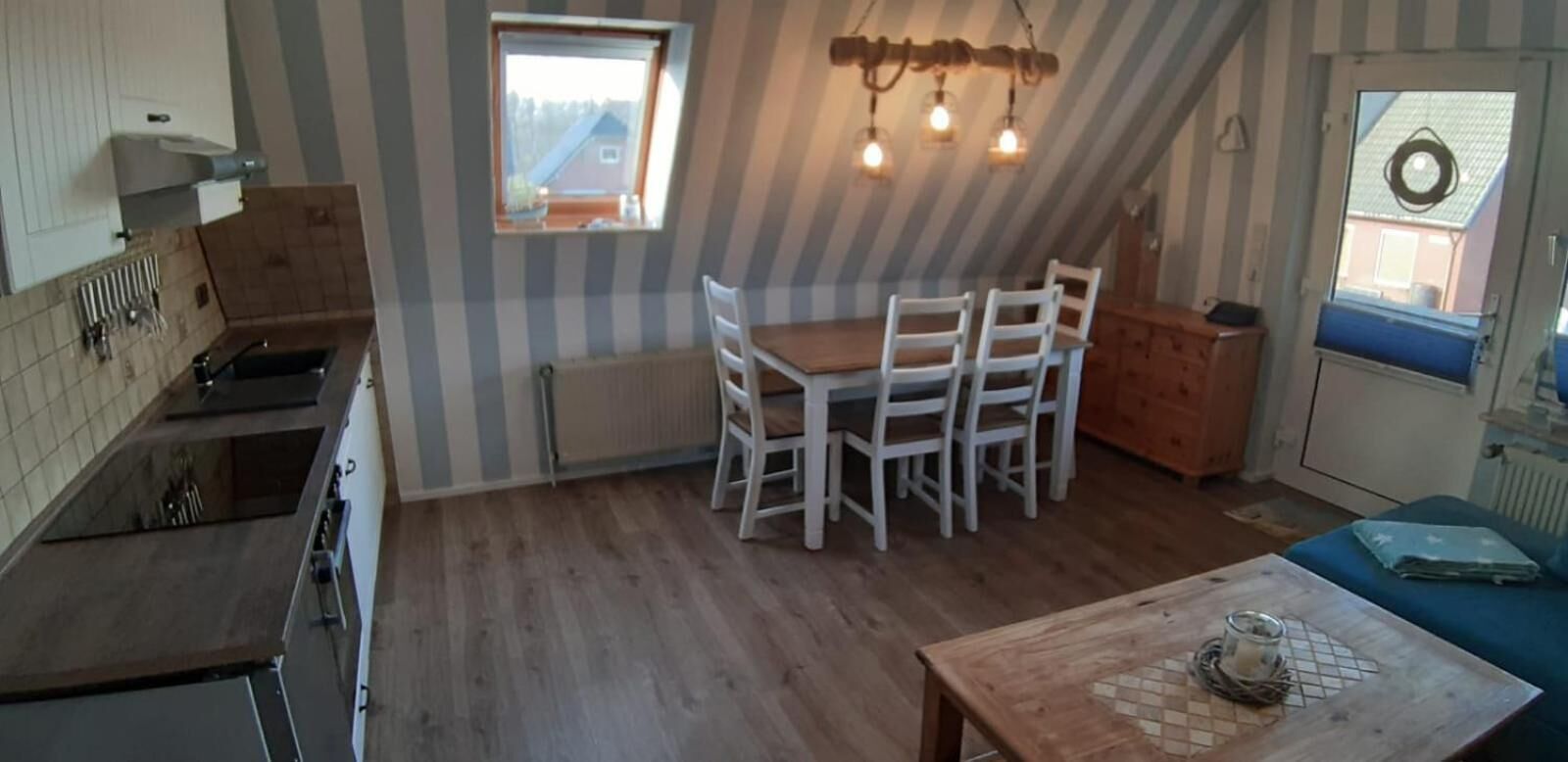 Una cocina con comedor, una ventana y una lámpara en el techo.