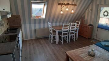 Una cocina con comedor, una ventana y una lámpara en el techo.