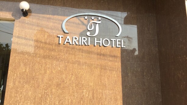 Een bord voor Hotel Tariri met een logo met daarin drie sterren en een halve maan.