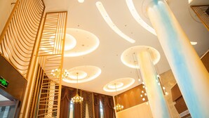 Un intérieur moderne avec un plafond incurvé, un éclairage encastré et une colonne centrale.