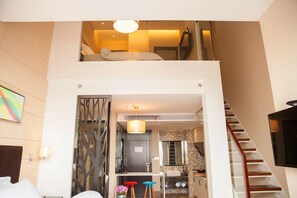 Une chambre d’hôtel moderne avec un balcon, un coin cuisine et un escalier.