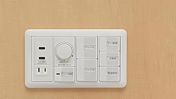 A white electrical panel with USB ports, a power switch, and Japanese labels.